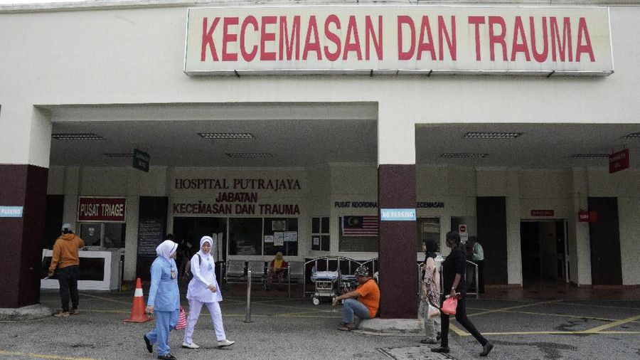 People walk outside the Putrajaya hospital in Putrajaya, Malaysia, Monday, Jan. 13, 2020. World top badminton player Kento Momota from Japan, was injured during a car accident in Malaysia early Monday and he is receiving a treatment at the hospital according to health minister.  (AP Photo/Vincent Thian)