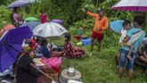 Petugas BPBD (kedua kanan) membujuk sejumlah warga yang mengungsi di atas tanggul untuk dievakuasi dari lokasi banjir di Desa Trimulyo, Guntur, Kabupaten Demak, Jawa Tengah, Kamis (9/1/2020). ANTARA FOTO/Aji Styawan