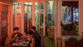 Dekorasi Pyongyang Bar dihiasi poster bergaya Korea Utara dan dinding berwarna hijau muda yang mengingatkan pada warna blok apartemen Pyongyang. (AFP/Ed Jones)