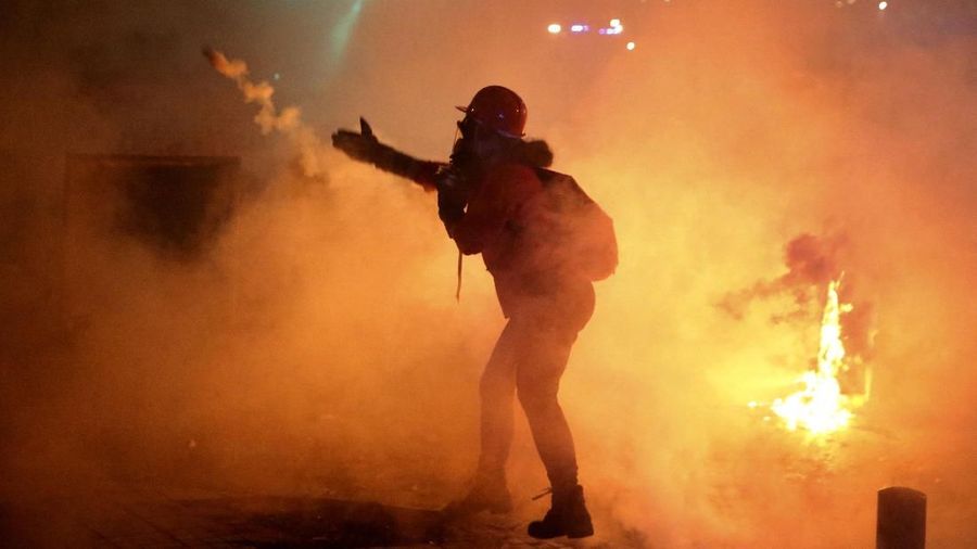 An anti-government protester destroys an ATM machine during ongoing protests against the Lebanese central bank's governor and against the deepening financial crisis, at Hamra trade street, in Beirut, Lebanon, Tuesday, Jan. 14, 2020. Lebanese security forces lobbed tear gas at protesters who responded with rocks outside the country's central bank Tuesday, a violent turn after demonstrators returned to the streets following a weekslong lull. (AP Photo/Hussein Malla)