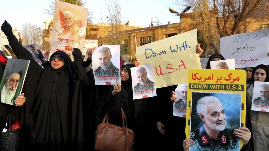 Protesters chant slogans and hold up posters of Gen. Qassem Soleimani during a demonstration in front of the British Embassy in Tehran, Iran, Sunday, Jan. 12, 2020. A candlelight ceremony late Saturday in Tehran turned into a protest, with hundreds of people chanting against the country's leaders — including Supreme Leader Ayatollah Ali Khamenei — and police dispersing them with tear gas. Police briefly detained the British ambassador to Iran, Rob Macaire, who said he went to the Saturday vigil without knowing it would turn into a protest. (AP Photo/Ebrahim Noroozi)