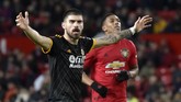 Gelandang Wolverhampton Ruben Neves mempertanyakan keputusan wasit menganulir gol Pedro Neto ke gawang MU. Wasit menganulir gol setelah melihat Video Assistant Referee (VAR) karena Raul Jimenez terlebih dahulu handball. (AP Photo/Rui Vieira)