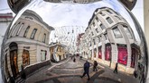 Refleksi para pejalan kaku terlihat dari ornamen dekorasi Tahun Baru di pusat Moskow, Rusia. (AFP/Yuri Kadobnov)
