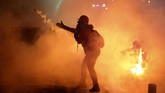 Polisi menembakkan gas air mata dan kembang api serta melempari massa demonstran dengan botol air minum dan batu. Aparat juga menangkap sejumlah demonstran yang diduga memicu kerusuhan. (AP Photo/Hussein Malla)