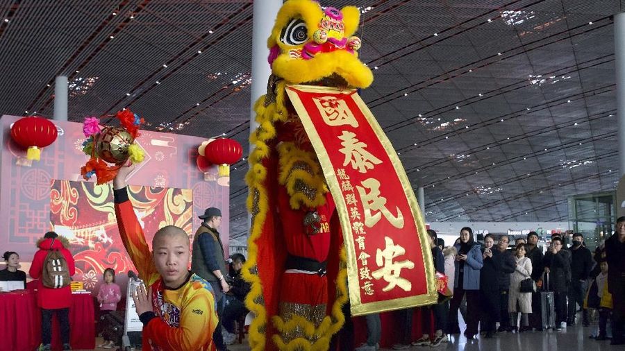 Wisatawan menonton pertunjukan tarian singa di Bandara Internasional Ibukota Beijing di Beijing, Jumat, 17 Januari 2020.  (AP Photo/Ng Han Guan)