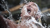 Sebelum melakukan ritual mandi es ini, para peserta biasanya akan melakukan pemansan dan menyanyikan puji-pujian. (Photo by Behrouz MEHRI / AFP)
