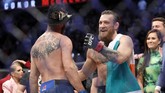 McGregor memeluk 'Cowboy' Cerrone setelah laga UFC 246. Kekalahan dari McGregor merupakan yang ke-14 dalam karier petarung 36 tahun tersebut. (Steve Marcus/Getty Images/AFP)