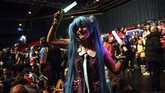 Seorang penggemar yang berdandan ala Hatsune Miku terlihat larut dalam penampilan sang idola di Paris. (Photo by Christophe ARCHAMBAULT / AFP)