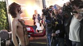 Wartawan foto mengabadikan aksi seorang aktivis lingkungan hidup yang berdemonstrasi di Brussels Motor Show 2020. (Photo by FranÁois WALSCHAERTS / AFP)