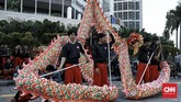 Atraksi Liong dari Naga Merah Putih Bogor menghibur pejalan kaki yang melintas di kawasan bundaran Hotel Indonesia (HI), Jakarta, Kamis (23/1). (CNN Indonesia/Andry Novelino)