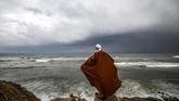 Seorang pria Palestina berdiri di tengah pantai saat badai melanda rumahnya di perkampungan al-Shati di kota Gaza. (Photo by MOHAMMED ABED / AFP)