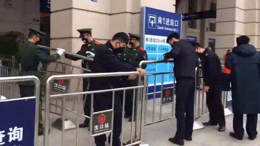Polisi paramiliter berjaga di pintu masuk Stasiun Kereta Api Hankou yang ditutup di Wuhan di Provinsi Hubei, China tengah. (The Paper via AP)