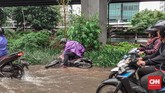 Seorang pengendara sepeda motor jatuh saat melintasi genangan air akibat hujan deras di Jalan Ahmad Yani, Jakarta Timur, Jumat (24/01/2020). (CNN Indonesia/ Adhi Wicaksono)