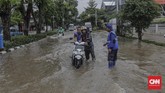 Sebagian pengendara memilih berhenti hingga air surut. Namun tak jarang mereka memaksa menerobos dengan risiko motor mati mendadak. (CNN Indonesia/ Adhi Wicaksono)