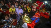 Pengurus Vihara yang berdandan ala Dewa Uang Cai Shen membagikan angpao kepada warga yang sembahyang di Vihara Boen San Bio, Pasar Baru, Kota Tangerang, Jumat (24/1). Pembagian angpao merupakan tradisi saat perayaan Imlek yang mengambil kisah cerita dari Dewa Uang Cai Shen. (ANTARA FOTO/Fauzan/ama).