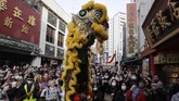 Masyarakat menonton pertunjukan tari singa saat perayaan Tahun baru Imlek di Pecinan, Yokohama, Jepang, Sabtu (25/1). (AP Photo/Jae C. Hong)