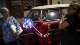 Seorang penari muda dari Asosiasi Wushu Kuba pulang ke rumah bersama ibunya setelah tampil selama upacara perayaan Tahun Baru Imlek di Havana, Kuba pada Jumat (24/1). (AP Photo/Ramon Espinosa)