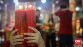 Tahapan membakar lilin sebagai doa untuk Dewa Langit agar kesehatan, rejeki dan keluarga berjalan lancar. (CNNIndonesia/Safir Makki)