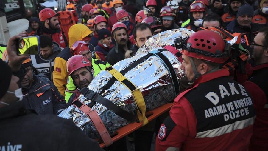 Members of rescue services carry a wounded man, that was found in the rubble of a building destroyed on Friday's earthquake in Elazig, eastern Turkey, Saturday Jan. 25, 2020. Rescue workers were continuing to search for people buried under the rubble of apartment blocks in Elazig and neighbouring Malatya. Mosques, schools, sports halls and student dormitories were opened for hundreds who left their homes after the quake (IHH/ Humanitarian Relief Foundation via AP)