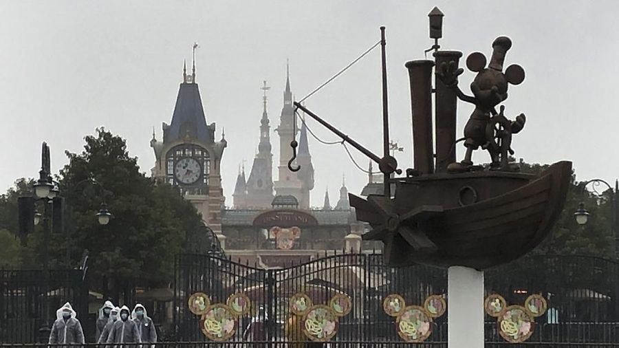 Security personnel wear face masks as they stand at the gate of the Shanghai Disney Resort, which announced that it will be closed indefinitely from Saturday, in Shanghai, Saturday, Jan. 25, 2020. China's most festive holiday began in the shadow of a worrying new virus Saturday as the death toll surpassed 40, an unprecedented lockdown that kept people from traveling was expanded to more than 50 million residents and authorities canceled a host of Lunar New Year events. (AP Photo/Fu Ting)