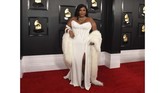 Lizzo menampilkan gaya Hollywood era klasik dengan gaun putih Versace lengkap dengan detail bulu. (Photo by Jordan Strauss/Invision/AP)