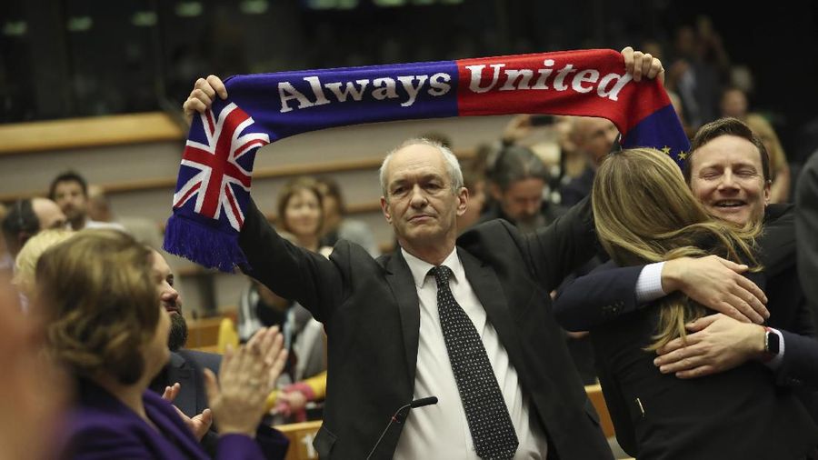 British MEP Richard Corbett holds a banner after a vote on the UK's withdrawal from the EU, the final legislative step in the Brexit proceedings, during the plenary session at the European Parliament in Brussels, Wednesday, Jan. 29, 2020. The U.K. is due to leave the EU on Friday, Jan. 31, 2020, the first nation in the bloc to do so. (AP Photo/Francisco Seco, Pool)