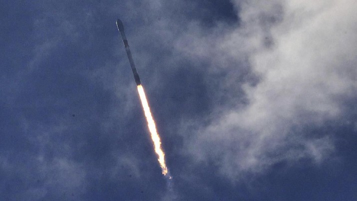 A SpaceX Falcon 9 rocket passes through clouds during launch from Cape Canaveral Air Force Station, in this view from Playalinda Beach at Canaveral National Seashore, Wednesday, Jan. 29, 2020. The rocket was carrying 60 Starlink satellites, the fourth launch of the SpaceX Starlink mission. (Joe Burbank/Orlando Sentinel via AP)
