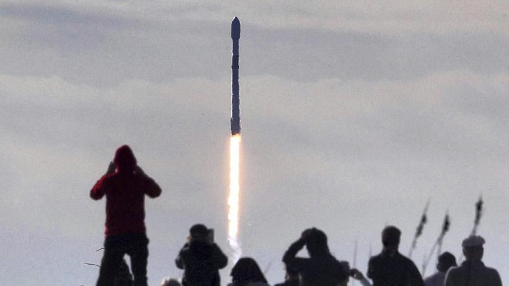 Roket Falcon 9 SpaceX dengan muatan sekitar 60 satelit untuk jaringan broadband Starlink SpaceX lepas landas dari Space Launch Complex 40 di Stasiun Angkatan Udara Cape Canaveral di Cape Canaveral, Florida, Rabu, (29/1/2020). (Joe Burbank/Orlando Sentinel via AP) In this view from Playalinda Beach at Canaveral National Seashore, visitors watch a Falcon 9 SpaceX rocket with a payload of approximately 60 satellites for SpaceX's Starlink broadband network lift off from Space Launch Complex 40 at the Cape Canaveral Air Force Station in Cape Canaveral, Fla., Wednesday, Jan. 29, 2020. (Joe Burbank/Orlando Sentinel via AP)