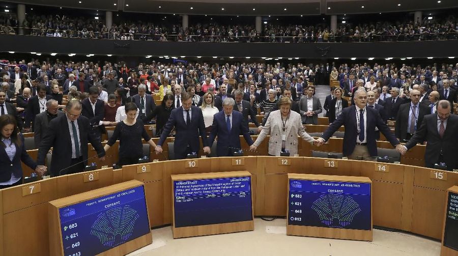 MEP's sing and hold hands after a vote on the UK's withdrawal from the EU, the final legislative step in the Brexit proceedings, during the plenary session at the European Parliament in Brussels, Wednesday, Jan. 29, 2020. The U.K. is due to leave the EU on Friday, Jan. 31, 2020, the first nation in the bloc to do so. (Yves Herman, Pool Photo via AP)