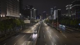 Jalanan sepi kota Wuhan di malam hari. Untuk saling menguatkan karena kota yang terisolasi, warga Wuhan dari jendela rumah dan apartemen masing-masing berteriak saling menguatkan, 'Jiayou'. Video saling menyemangati itu pun viral. (AFP/Hector RETAMAL)