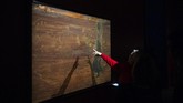 Seorang pengunjung menunjuk karya seni Salvador Dali yakni 'Raphaelesque Hallucination' di Manege Central Exhibition Hall, Russia pada Selasa (28/1). (AP Photo/Pavel Golovkin)