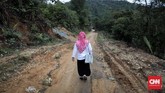 Dia adalah Arosel, guru honorer Sekolah Marginal di Dusun Sialang Harapan, Kampar, Riau. Setiap hari jalan kaki sejauh 6 km, melewati hutan dan membelah sungai, untuk bisa tiba di sekolah (CNNIndonesia/Safir Makki)
