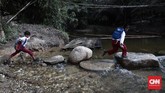 Batu adalah penolong siswa Sekolah Marginal di Riau. Tetapi tidak jika hujan turun, karena volume air sungai meluap dan hanya perahu rakit yang bisa digunakan untuk menyeberang (CNNIndonesia/Safir Makki)
