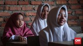 Senyum adalah kiat pertama siswa untuk bisa belajar dengan senang hati di Sekolah Marginal, Riau untuk menghadapi pemandangan bobrok ruang kelasnya (CNNIndonesia/Safir Makki)