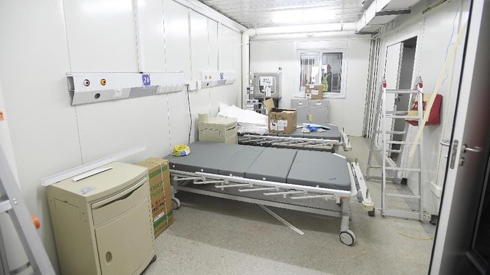 A Chinese army medic looks at a patient room at the Huoshenshan temporary field hospital in Wuhan in central China's Hubei Province, Sunday, Feb. 2, 2020. The Philippines on Sunday reported the first death from a new virus outside of China, where authorities delayed the opening of schools in the worst-hit province and tightened quarantine measures in a city that allow only one family member to venture out to buy supplies. (Chinatopix via AP)