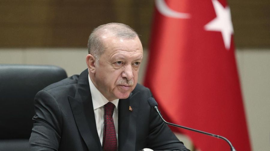 Turkish President Recep Tayyip Erdogan speaks to reporters before departing for a visit to Ukraine, in Istanbul, Monday, Feb. 3, 2020. Turkey hit targets in northern Syria, responding to shelling by Syrian government forces that killed at least four Turkish soldiers, the Turkish president said Monday. A Syrian war monitor said six Syrian troops were also killed.(Presidential Press Service via AP, Pool)