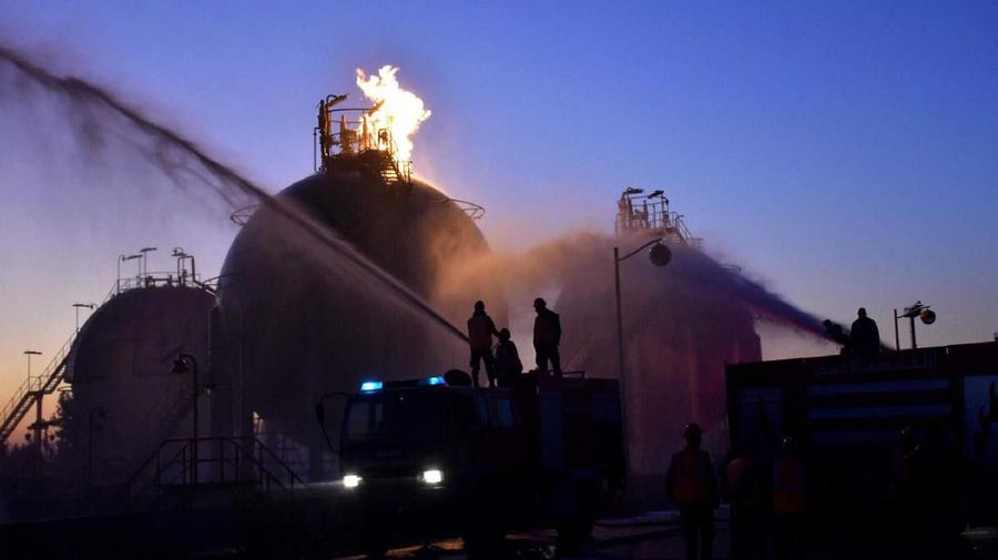 In this photo provided by SANA, Syria's state news agency, workers respond to an attack on Homs oil refinery on Saturday, Dec. 21, 2019 in Homs, Syria. Near-simultaneous attacks believed to have been carried out by drones hit three government-run oil and gas installations in central Syria, state TV and the Oil Ministry said Saturday. (SANA via AP)