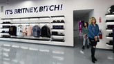 Merchandise itu meliputi pakaian hangat, jaket, topi, sampai pernak-pernik. Frasa populer yang diambil dari lagu Gimme More dipajang di dinding. (Photo by Frederic J. BROWN / AFP)