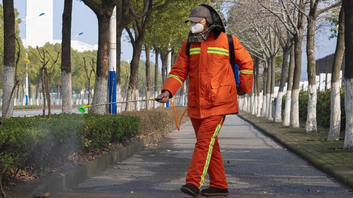 FILE - In this Jan. 28, 2020, file photo, a worker wearing a face mask sprays disinfectant along a path in Wuhan in central China's Hubei Province. Halting the spread of a new virus that has killed hundreds in China is difficult in part because important details about the illness and how it spreads are still unknown. (AP Photo/Arek Rataj, File)
