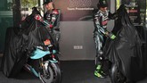 Fabio Quartararo dan Franco Morbidelli membuka kerudung yang menutup sepeda motor YZR-M1 yang digunakan Petronas Yamaha di MotoGP 2020. (MOHD RASFAN/AFP)