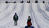 Pengunjung bermain snow rafting dalam Sapporo Snow Festival 2020. (CHARLY TRIBALLEAU / AFP)