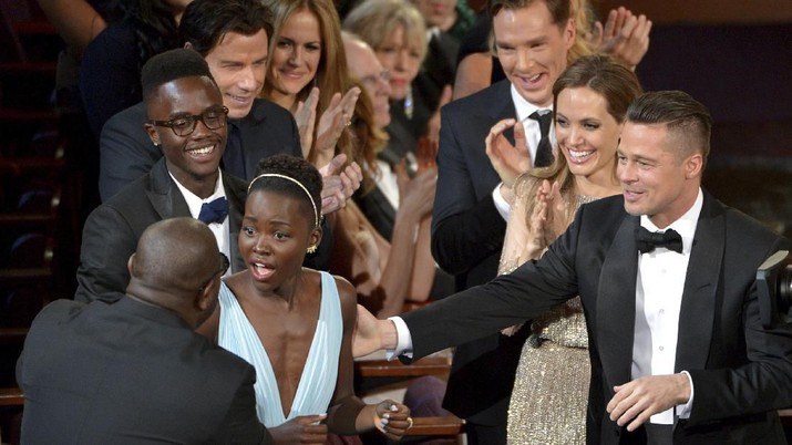 FILE - In this March 2, 2014 file photo, director Steve McQueen, left, congratulates Lupita Nyong'o on her win for best actress in a supporting role for 