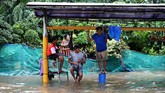 Warga menunggu surutnya banjir di Jalan Letjen Suprapto, Jakarta Pusat, Sabtu (8/2/2020). PLN sempat memadamkan 126 gardu listrik di Jakarta untuk menjaga kondisi tetap aman. (ANTARA FOTO/Sigid Kurniawan/wsj).