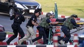 Puluhan pembeli yang masih dalam keadaan terkejut bergegas melarikan diri dari pusat perbelanjaan ketika polisi memasuki mal. Salah satu warga yang berhasil lolos dari insiden itu menceritakan, hari Sabtu mereka berubah menjadi horor akibat kejadian tersebut. (AP Photo/Wason Wanichakorn)