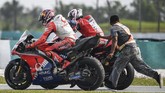 Jack Miller mendapat bantuan dari pebalap Ducati Danilo Petrucci untuk kembali ke paddock Pramac Racing usai mengalami kecelakaan. (Mohd RASFAN / AFP)