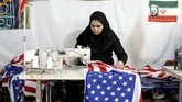 Pemilik pabrik enggan mengungkap berapa keuntungan yang mereka dapat dari membuat replika bendera AS, Israel dan Inggris untuk dibakar. (AP Photo/Ebrahim Noroozi)