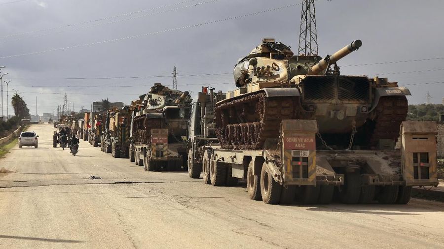 Turkish military convoy drives through the village of Binnish, in Idlib province, Syria, Saturday, Feb. 8, 2020. Several Turkish armored vehicles and tanks entered rebel-controlled northwestern Syria since Friday, the latest reinforcements sent in by Ankara amid a Syrian government offensive that this week brought the two countries' troops into a rare direct confrontation. (AP Photo/Ghaith Alsayed)