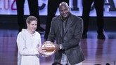 Michael Jordan menyerahkan bola kepada Presiden Chicago Bulls Michael Reinsdorf Jr. ketika Charlotte Hornets menjadi tuan rumah NBA All Star 2019. Chicago Bulls menjadi tuan rumah NBA All Star tahun ini. (Jeff Hahne/Getty Images/AFP)