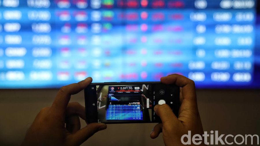 Pengunjung berada di sekitar layar pergerakan Indeks Harga Saham Gabungan (IHSG) di Bursa Efek Indonesia (BEI) Jakarta, Kamis (13/2). Indeks Harga Saham Gabungan (IHSG) di Bursa Efek Indonesia (BEI) hari ini pukul 12.00 menurun-0,67% ke posisi 5,873,30. Pergerakan IHSG ini masih dipengaruhi oleh sentimen atas ketakutan pasar akan penyebaran wabah virus corona.