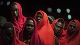 Sekelompok migran yang diselamatkan oleh otoritas maritim Spanyol tengah berdiri di atas kapal penyelamat ketika tiba di pelabuhan Malaga, Spanyol, Selasa (11/2). (AP Photo/Jesus Merida)